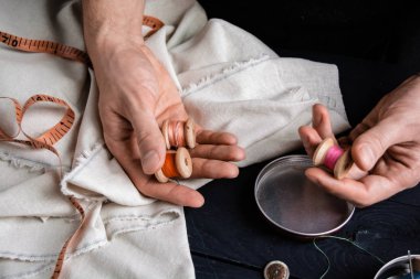 İplik makarası tutan terzi sanatkâr.