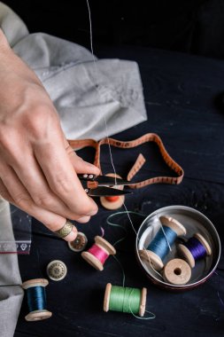 Bir iş parçacığı makasla kesme terzi, siyah arka plan, kapatmak