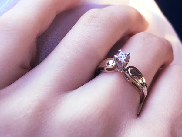 关闭优雅的钻石戒指的手指与灰色的围巾背景。钻戒. — 图库照片