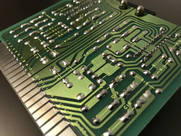 Tiro da parte de trás de uma placa de circuito de computador verde sobre fundo preto — Fotografia de Stock