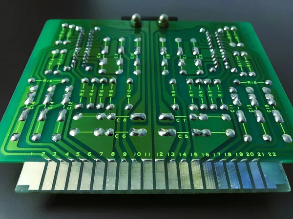 Shot of the back side of a green computer circuit board on black background — Stock Photo, Image