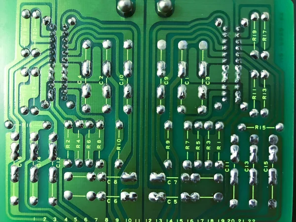 Shot of the back side of a green computer circuit board on black background — Stock Photo, Image