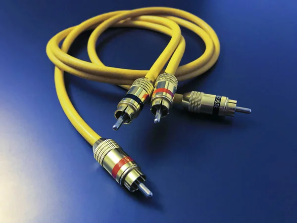Stereo-Audio-Verlängerung gelbes Kabel isoliert auf blauem Hintergrund — Stockfoto