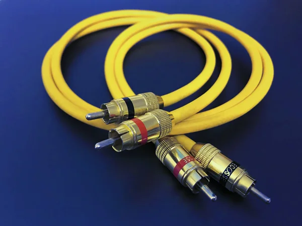 Cable amarillo de extensión de audio estéreo aislado sobre fondo azul —  Fotos de Stock