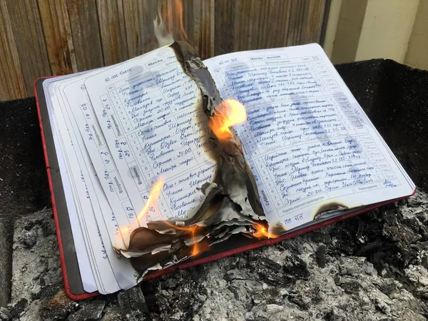 School diary with daily hand written note burning in fire flame — Stock Photo, Image