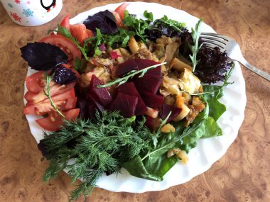 Beyaz bir tabaktabaküzerinde otlar ile ev yapımı haşlanmış sebze