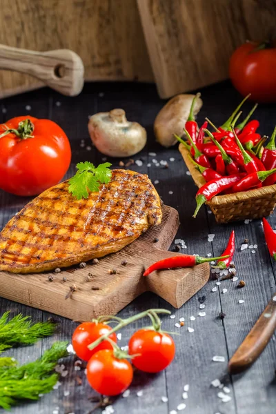 grilled kebab grilled meat steak lies on a wooden vintage old board rustic, chili, with tomatoes, sauce, dill onions, on the table on top, side, bottom shot angle, fork and knife mushrooms