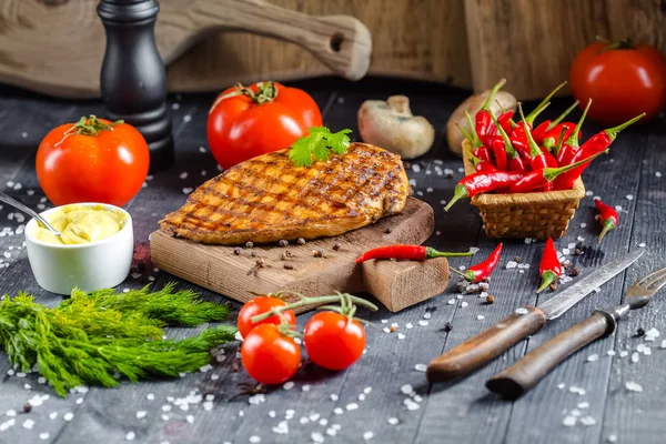grilled kebab grilled meat steak lies on a wooden vintage old board rustic, chili, with tomatoes, sauce, dill onions, on the table on top, side, bottom shot angle, fork and knife mushrooms