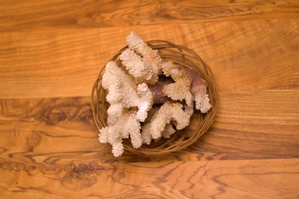 Coral em uma cesta de vime na mesa — Fotografia de Stock