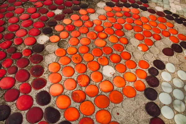 Yuvarlak turuncu, kırmızı ve kahverengi smalt tan yapılmış doku eski mozaik beton gömülü.