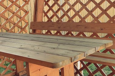 Ahşap bir masası ve dikey tahtalardan çitleri olan çevre dostu bir avlu. Çevre dostu veranda. Yakın çekim..