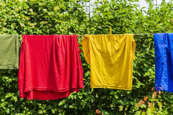 Dry blankets after washing in the sun on a wire in the garden outside the house