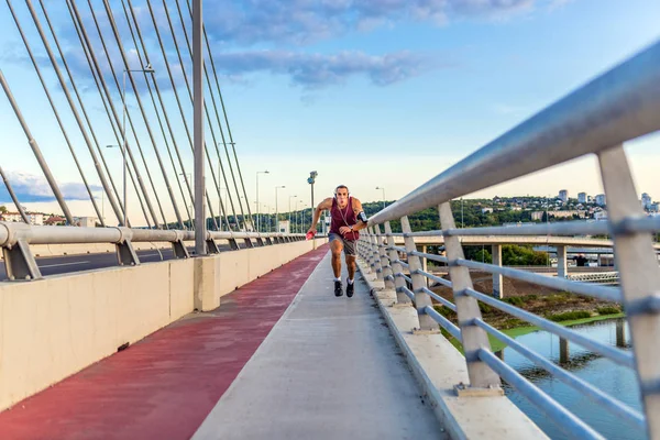 Fitness man jogging on a bridge.Athlete man running jogging on bridge .