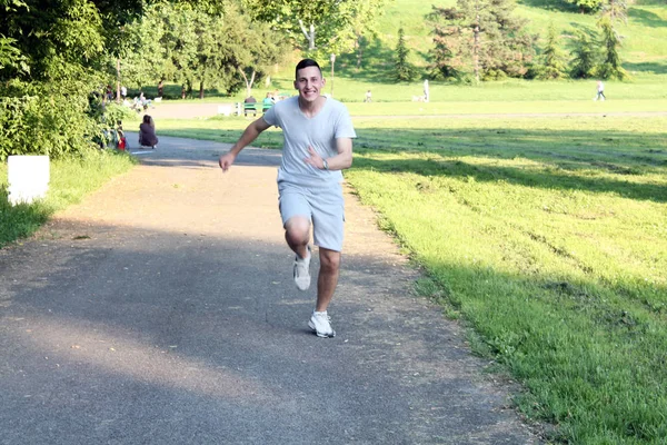 Handsome young sportsman is running and jogging in the public park