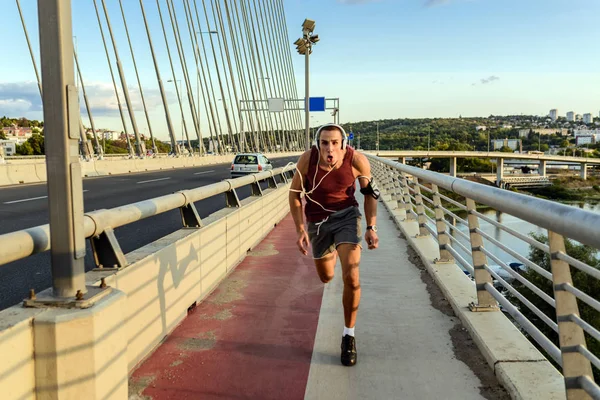Fitness man jogging on a bridge.Athlete man running jogging on bridge .