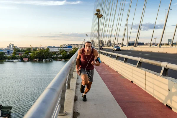 Fitness man jogging on a bridge.Athlete man running jogging on bridge .