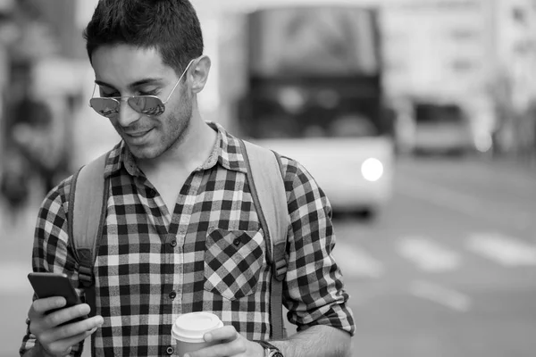 Handsome man sending text message.