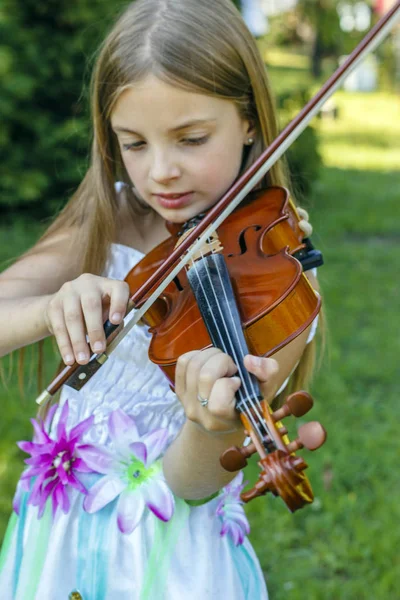 Little girl play violin in park