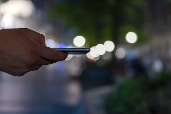 Close up View of Businessman with a Smart Phone in the City Streets During a Night