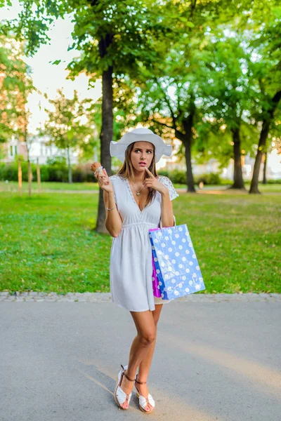 Happy young woman with ice cream on city street