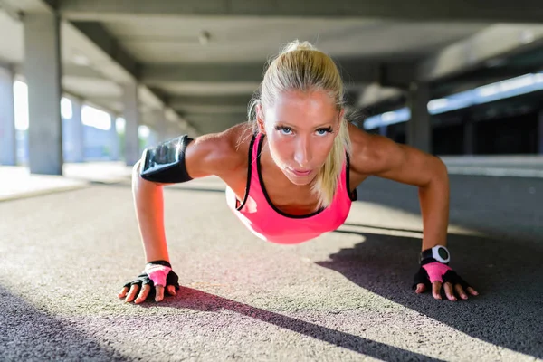 athletic woman doing push ups in the street, healthy lifestyle concept.