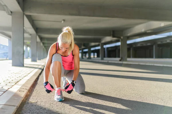 Unrecognizable young runner tying her shoelaces