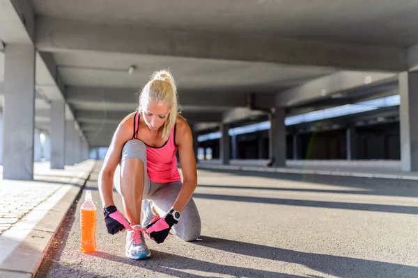 Unrecognizable young runner tying her shoelaces