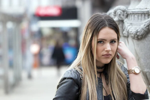 Portrait stressed sad young woman standing outdoors. City life style stress.