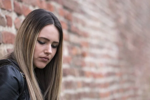 Portrait stressed sad young woman standing outdoors. City life style stress.