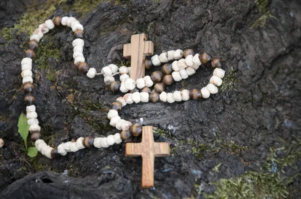 Old wooden cross and beads on the tree