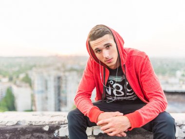 Arka planda gün batımında kulaklıklar tarafından müzik dinleme Manly ama romantik spor adam