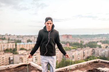 egzersiz ve yaşam tarzı kavramı-adam çatıdaki atlama ip açık havada atlama
