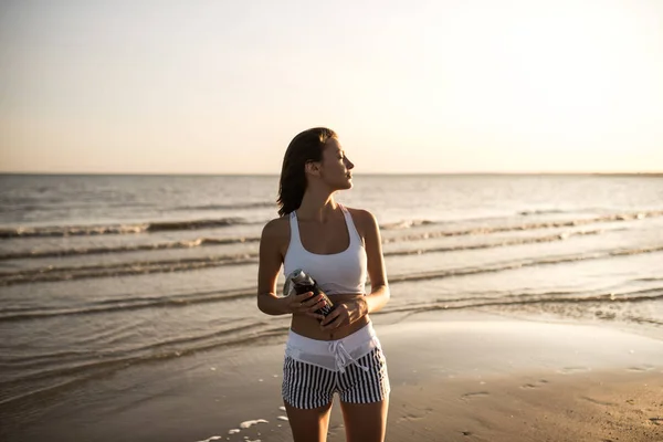 Mutlu kaygısız sportif kadın plajda güzel gün batımı zevk — Stok fotoğraf