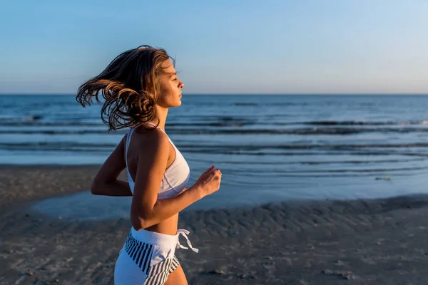 Jonge slanke mooie vrouw lopen op zonsondergang met positieve stemming — Stockfoto