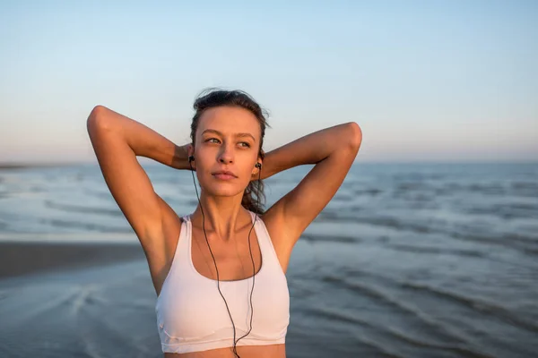 Spor fitness egzersiz kadın plajda müzik dinlerken — Stok fotoğraf