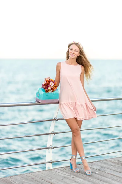 Belles femmes avec des fleurs sur la plage feals heureux — Photo