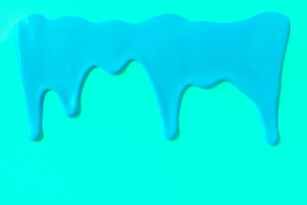 Blue paint leaking down cyan background — Stock Photo, Image