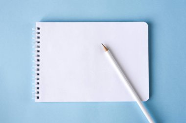 Mavi arka plan üzerine bir kalem ve defter