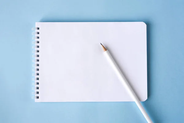 青い背景に鉛筆とノート — ストック写真