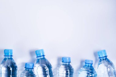Beyaz arka planda birçok içme suyu şişesi