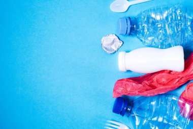 Mavi arkaplanda plastik çöp,