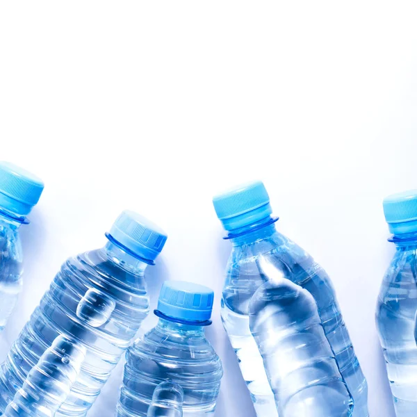 Several drinking water bottles on white background — Stock Photo, Image