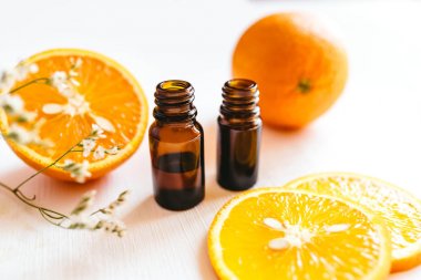 Beyaz arka planda turuncu uçucu yağ iki şişe