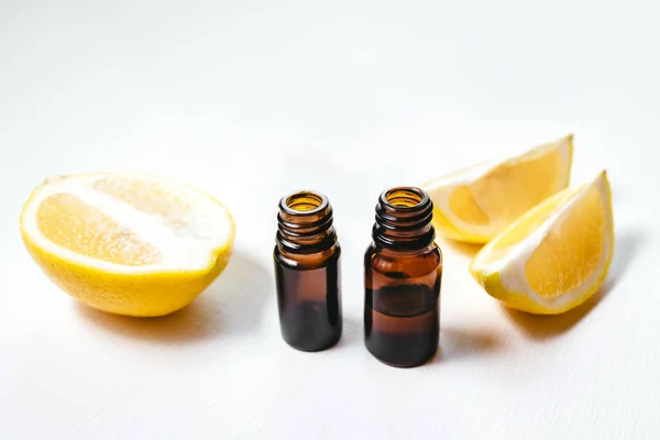 Duas garrafas de óleo essencial de limão no fundo branco — Fotografia de Stock