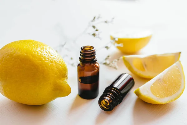 Beyaz arka planda limon esansiyel yağı iki şişe
