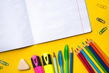 Sarı arka planda okul malzemeleri
