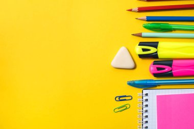 Sarı arka planda okul malzemeleri