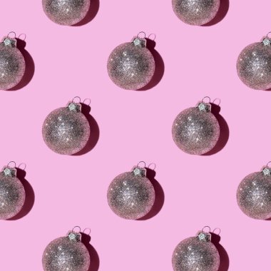 Pembe arka planda gümüş toplarından yapılmış desen.