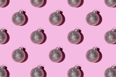 Pembe arka planda gümüş toplarından yapılmış desen.