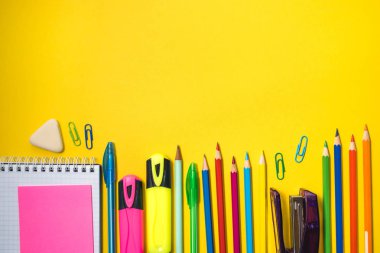 Sarı arka planda okul malzemeleri